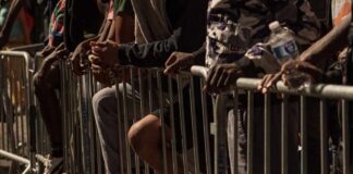 People leaning on barriers at an outdoor event