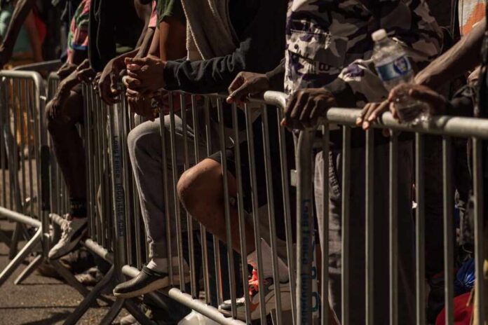 People leaning on barriers at an outdoor event