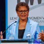 Woman speaking at a podium in blue jacket