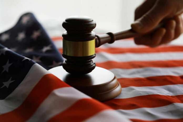 Gavel and hand on American flag.