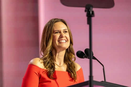 shuckabee-sanders2524663801jpg Woman in red dress speaking at podium smiling