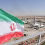 No Sunset: Iran Nuclear Showdown Returns Iranian flag waving in front of an oil processing facility