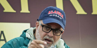 Man speaking passionately into a microphone at an outdoor event