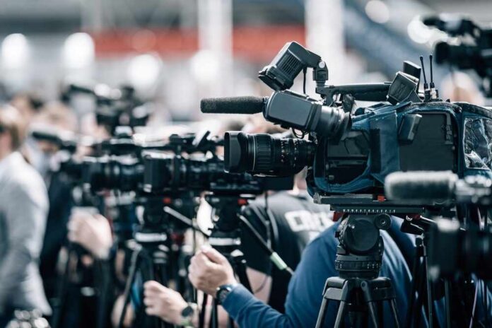 Row of cameras set up for a press event