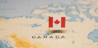 A small Canadian flag pinned on a map indicating Canada
