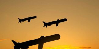 Silhouettes of missiles flying against a sunset backdrop