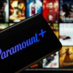 Mobile device displaying the Paramount Plus logo with a movie selection in the background
