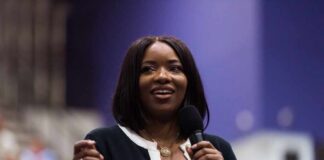 A woman speaking into a microphone with a smile