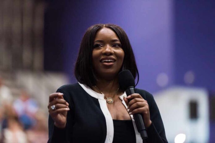 A woman speaking into a microphone with a smile