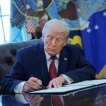 Donald Trump signing documents in the Oval Office