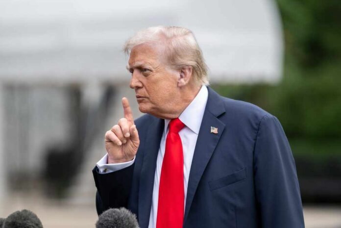 A man in a suit gesturing with his finger during a press conference