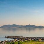 A tranquil landscape featuring mountains reflected in calm water