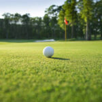 Golf ball on grassy golf course near hole