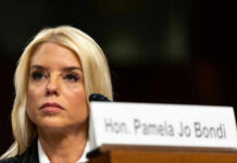 Woman seated next to nameplate at event