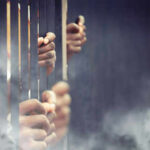 Hands gripping prison bars in smoky atmosphere