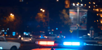 Police car with flashing blue and red lights in a city at night