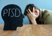 Silhouette of a head with 'PTSD' written on it, with a person in distress in the background