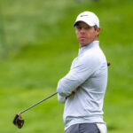 A golfer in sportswear looking intently on the golf course
