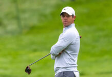 A golfer in sportswear looking intently on the golf course