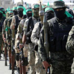 Uniformed individuals in a military parade holding weapons