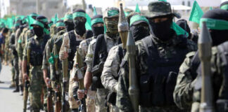 Uniformed individuals in a military parade holding weapons