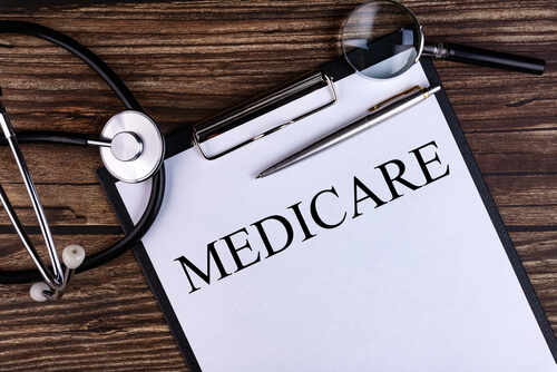 A document labeled 'Medicare' with a stethoscope and magnifying glass on a wooden surface