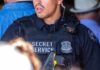 A Secret Service officer in tactical gear with a radio and firearm