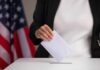 Person casting a ballot into a voting box