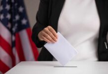 Person casting a ballot into a voting box
