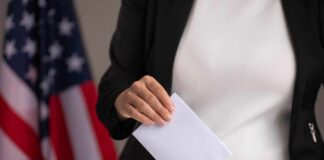 Person casting a ballot into a voting box