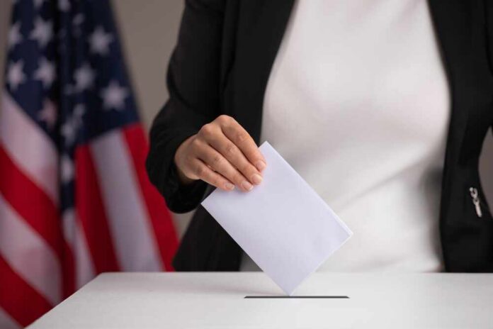 Person casting a ballot into a voting box