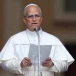 A religious leader speaking at a podium outdoors