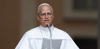 A religious leader speaking at a podium outdoors