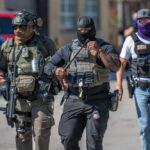 Group of police officers in tactical gear walking in an urban area