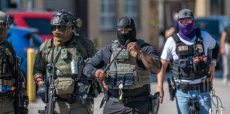 Group of police officers in tactical gear walking in an urban area