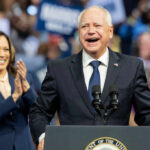 Two people speaking at a public event smiles cheering