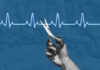 Hand holding scissors near heartbeat line illustration