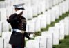 SILENT MISSION: 250,000 Flags Blanket Arlington A soldier in uniform saluting in a military cemetery with white gravestones in the background