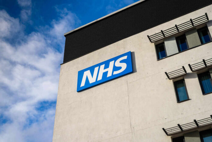 NHS sign on modern hospital building exterior