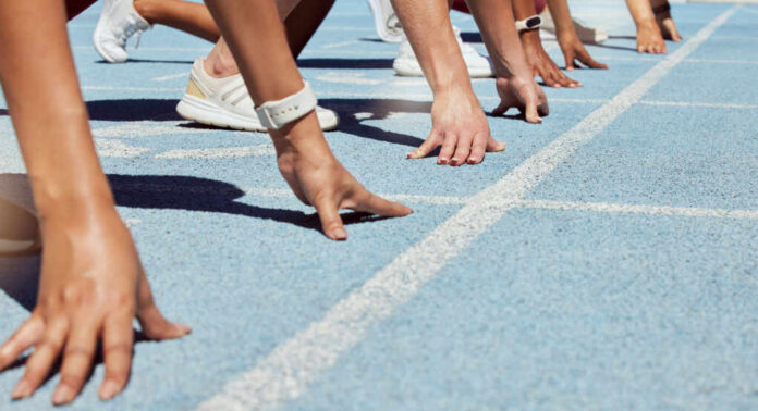 ready-to-compete-in-track-and-field2175132111jpg Athletes at starting line on blue track race