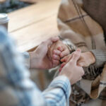 Two people holding hands in a cozy setting