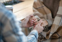 Two people holding hands in a cozy setting