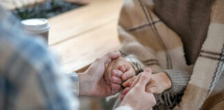 Two people holding hands in a cozy setting