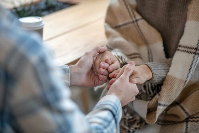 Two people holding hands in a cozy setting