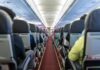 Interior view of an airplane aisle with passenger seats