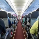 Interior view of an airplane aisle with passenger seats