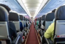Interior view of an airplane aisle with passenger seats