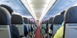 Interior view of an airplane aisle with passenger seats