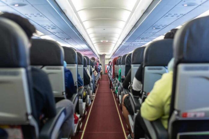 Interior view of an airplane aisle with passenger seats