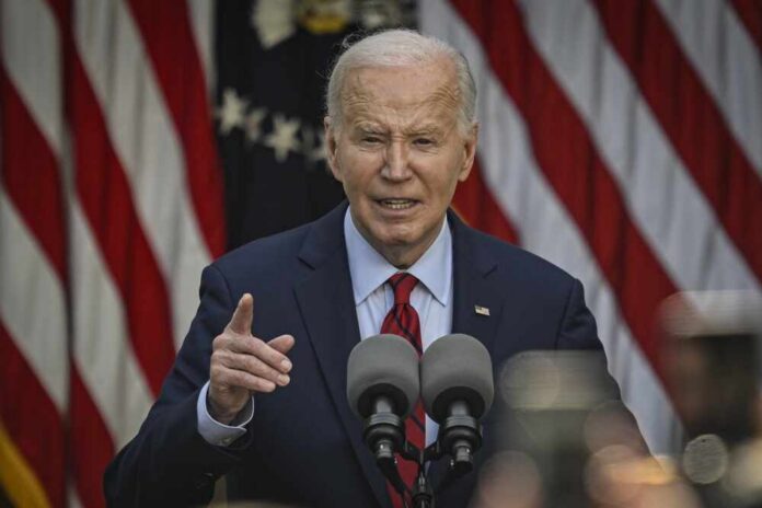 A man speaking at a podium with microphones in front of American flags